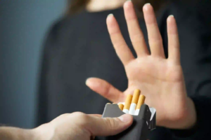 Person refusing offered cigarettes with a raised hand, symbolizing anti-smoking message and personal choice.