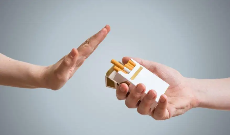 Two hands facing each other—one offering a pack of cigarettes, the other raised in a clear refusal gesture, visually expressing the act of rejecting smoking.