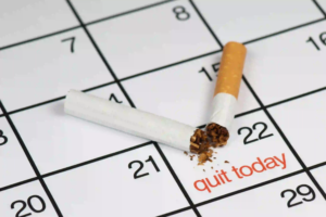 Broken cigarette spilling tobacco on a calendar, with the date '22' marked in red with the message 'quit today